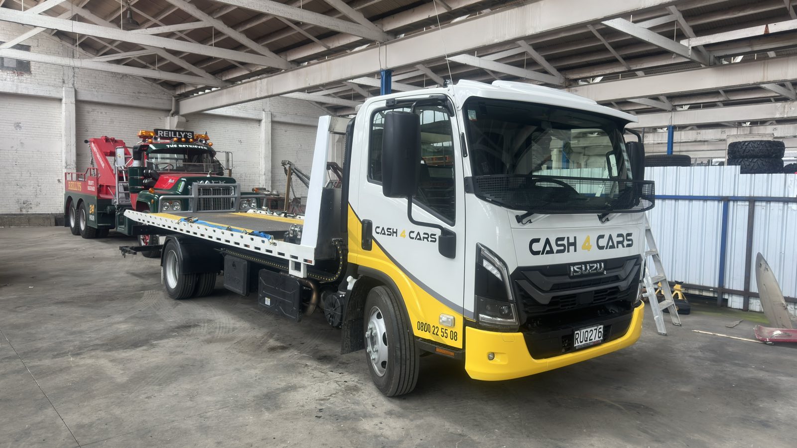 Cash 4 Cars flatbed removal truck parked in a vehicle depot